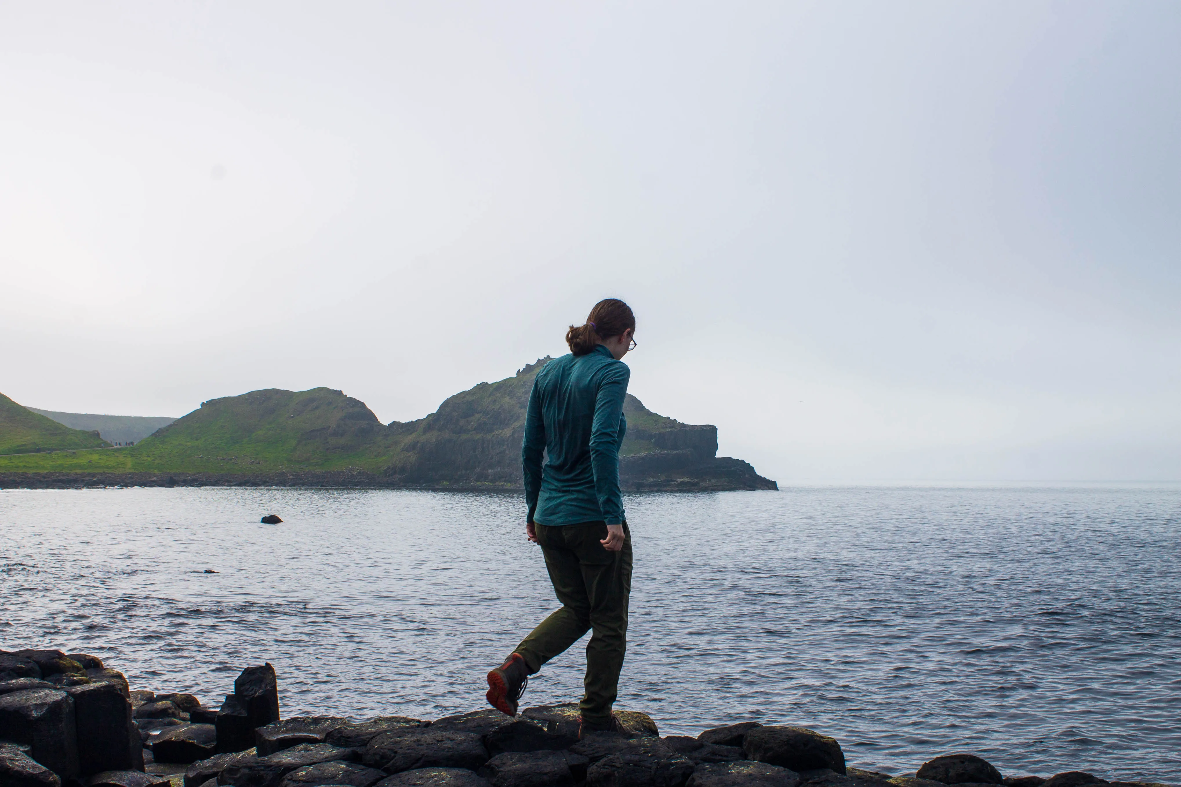 A woman walking across the Giant's Causeway